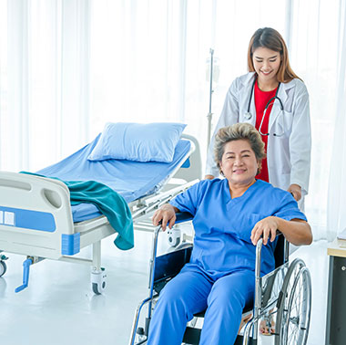 Woman leaving her hospital room in a wheelchair with nurse