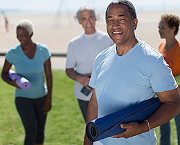 Retirees with yoga mats at beach