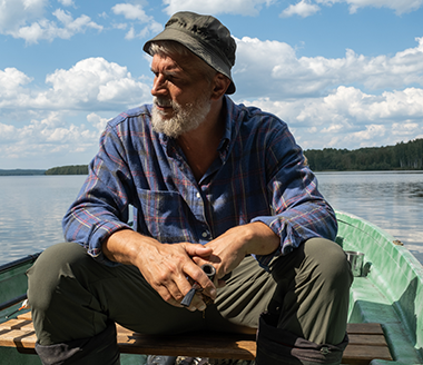 man contemplating life in rowboat on a lake