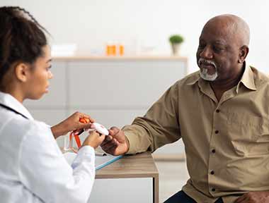senior man with nurse discussing medical alert system