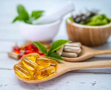 healthy supplements on wooden spoons green herbs