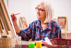 Woman painting at an easel in her studio
