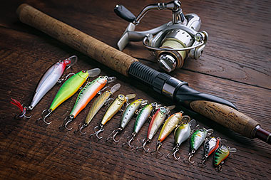 fishing tackle and rod against a wooden plank