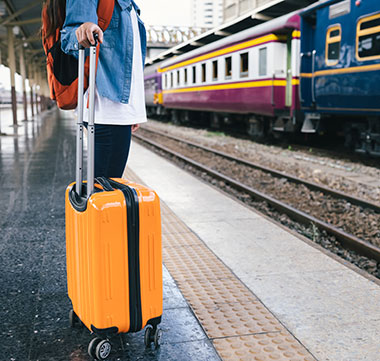 Person waiting at train station with luggage