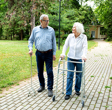seniors walking outdoors with mobility aids