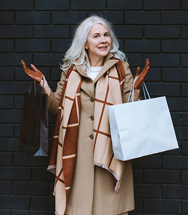 Woman smiling with shopping bag outside of store