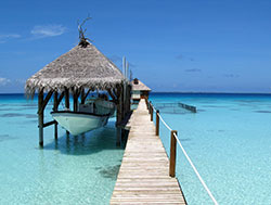 Hut over water with boat and wooden pier on Fakarava island