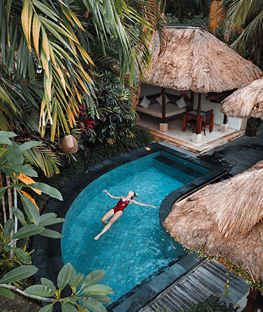 Woman swimming in a pool at a tropical health spa